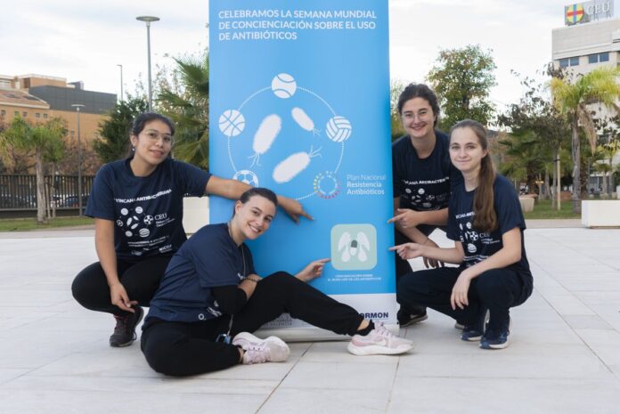 Alumnas posan junto al cartel de la yincana antibacteriana del CEU