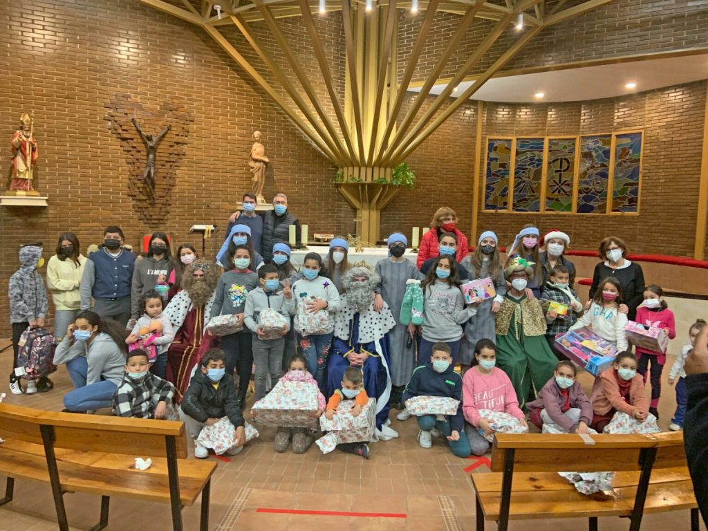 Niños y niñas reciben los regalos de la campaña de Navidad de Cáritas